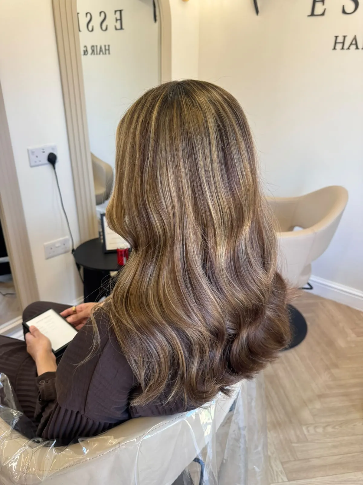 Long brunette hair with caramel balayage and soft waves at Essence Hair Treatment in Luton